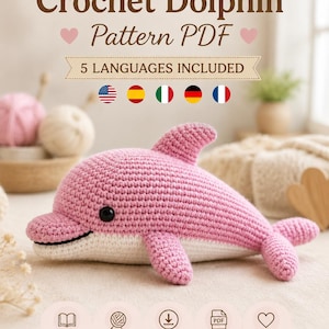 Puede incluir: Un patrón de delfín a ganchillo en PDF con el texto Crochet Dolphin Pattern PDF, 5 LANGUAGES INCLUDED y MiniZooPattern. La imagen muestra un juguete de delfín tejido a ganchillo en color rosa y blanco con aleta dorsal, aletas laterales y cola.