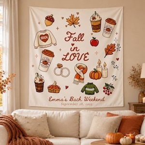 May include: A cream-colored wall tapestry featuring the text Fall in Love, Emma's Bach Weekend, and September 28, 2025. The design includes illustrations of an acorn, maple leaf, coffee cups, apple, pumpkin, candles, scarf, sweater, and rings.