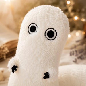 Puede incluir: Un peluche blanco con forma de fantasma, con ojos grandes y redondos y peque&ntilde;as manos negras con forma de garra. El juguete tiene una textura suave y difusa y est&aacute; dise&ntilde;ado para parecerse a un personaje de fantasma amigable.