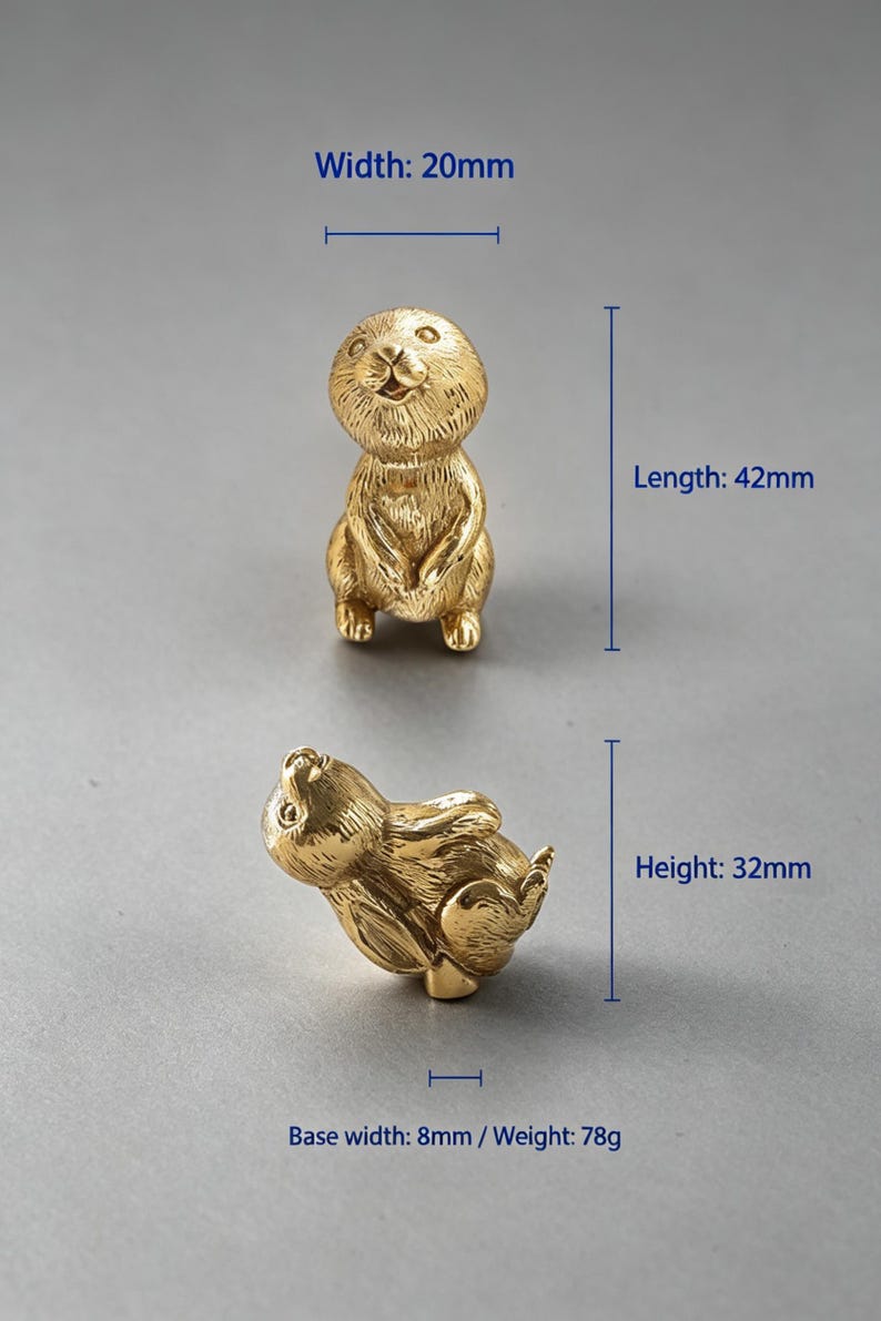May include: Two gold-coloured metal animal figurines shaped like prairie dogs. One stands upright, the other lies on its side. Dimensions are labelled as 20mm width, 42mm length, 32mm height, 8mm base width, and a weight of 78g for the objects.