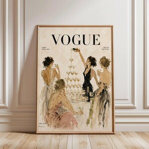 May include: A framed print of a Vogue magazine cover, depicting a champagne tower and women in evening gowns. The artwork has a vintage style, with the word "VOGUE" in bold black letters. The print includes the text "Paris Avril 1931 Haute Couture".