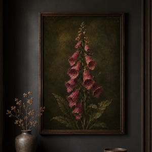 Puede incluir: Una impresión de arte mural enmarcada que presenta una ilustración botánica vertical de una planta dedalera alta con flores en forma de campana de color rosa oscuro y púrpura sobre un fondo verde oliva texturizado, oscuro y sombrío, en un marco de madera oscura.