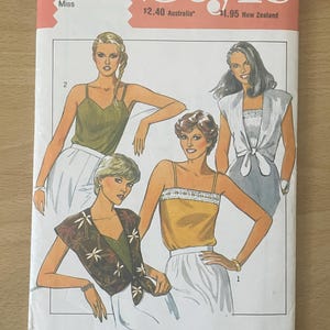 Peut inclure: Patron de couture vintage intitulé "Style", avec des illustrations de hauts et de jupes pour femmes. Le numéro du patron est 3385, et il comprend les tailles 10, 12, 14 et 16. La couverture est orange, rouge et blanche.