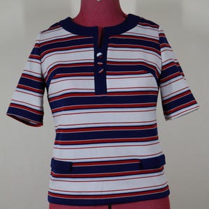 Vintage knit top with short sleeves, notched neckline with buttons, faux pocket flaps and bold navy, red, and white horizontal stripes