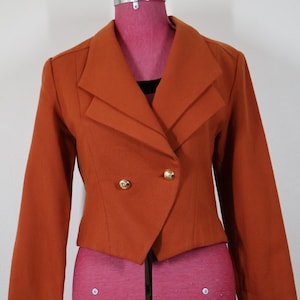 Vintage cropped rust-orange tailored jacket with oversized lapels, fitted waist and double-breasted accent with gold buttons and shaped hem
