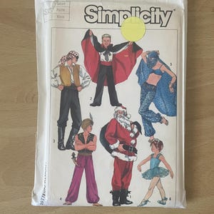 May include: Simplicity sewing pattern packet featuring costume designs. The packet shows illustrations of a pirate, magician, Santa Claus, and a ballerina. The packet is labeled with the number 7651 and the word "Simplicity".