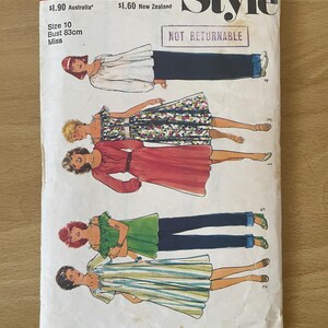 Könnte beinhalten: Ein Vintage-Schnittmuster für ein Kleid mit vier verschiedenen Stilen. Das Schnittmuster ist für Größe 10 mit einem Brustumfang von 83 cm. Das Schnittmuster ist mit "Style" und "Nicht Returnable" gekennzeichnet.