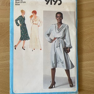 Op de afbeelding: Simplicity naaipatroon nummer 9193 voor een jurk. Het patroon is voor maat 12, borstomvang 87 cm, en is voor dames. Het patroon toont drie verschillende aanzichten van de jurk, een met een bloemenprint, een met een witte stof en een met een lichtblauwe stof. De jurk heeft een col en een strik in de taille.