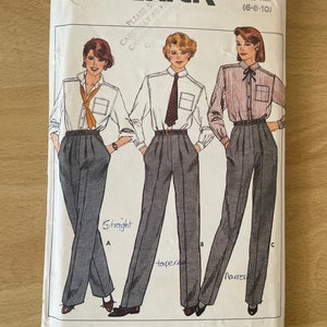 Può includere: Una busta di cartamodello Butterick vintage con illustrazioni di abbigliamento da lavoro femminile. La busta mostra tre diversi stili di pantaloni e camicie. Il numero del modello è 6879 e la taglia è (6-8-10).