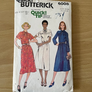 Può includere: Un cartamodello vintage per un abito con scollo a fiocco. Il cartamodello è per la taglia 10, seno 83 cm, e include istruzioni per trucchi salva tempo per tessuti morbidi. Il cartamodello è di Butterick e ha il numero 6008.