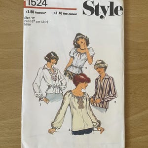 May include: A vintage sewing pattern for a blouse with a variety of styles. The pattern is for size 12, bust 87 cm, and is labelled "Style" with the number 1524. The pattern shows four different styles of blouses, including a white blouse with a ruffled neckline, a white blouse with a lace trim, a white blouse with a tie at the neckline, and a striped blouse.