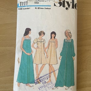 Op de afbeelding: Een vintage naai-patroon envelop met vier vrouwen die verschillende stijlen jurken dragen. Het patroonnummer is 1111 en de prijs is $ 1,40 in Australische dollars en $ 1,10 in Nieuw-Zeelandse dollars. De envelop heeft een stempel met de tekst "Geen restitutie of ruil voor papieren patronen".