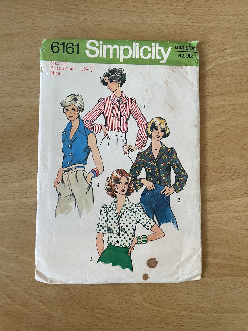 May include: Simplicity sewing pattern number 6161 for a size 12 miss, with a bust measurement of 87 cm (34 inches). The pattern includes instructions for making four different blouses with various sleeve lengths and necklines. The pattern cover features illustrations of models wearing the blouses.