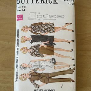 May include: A vintage sewing pattern for a cardigan, skirt, and trousers. The pattern is from Butterick and is number 5267. The pattern is for sizes 14 1/2 to 42.