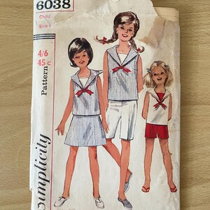 May include: Vintage Simplicity sewing pattern 6038 for child's sailor-style outfits. The pattern illustration shows three children in matching tops and bottoms. The pattern envelope is torn and shows the size and pattern details.
