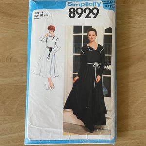 Puede incluir: Patrón de costura Simplicity número 8929 para un vestido. El patrón es para una talla 14, busto 92 cm, y es para mujeres. El patrón muestra un vestido blanco con una cinta negra y un vestido negro con una cinta blanca.