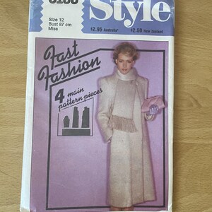 May include: A sewing pattern for a long coat with a fringe trim. The pattern is for size 12, bust 87 cm, and is labelled "Fast Fashion" and "Style".
