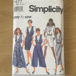 May include: A Simplicity sewing pattern packet, featuring illustrations of various women's outfits. The packet is white with the brand name and the words "easy to sew" printed on it. The pattern number is 1877.