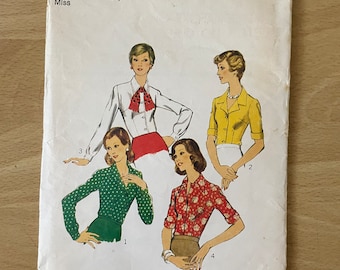 May include: A vintage sewing pattern for a blouse, featuring four different styles. The pattern is for size 10, with a bust measurement of 32 1/2 inches. The pattern is titled "Style" and has the number 4798 printed on it.