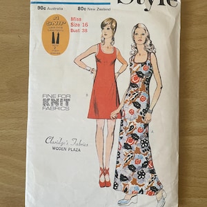 May include: A vintage sewing pattern for a dress, featuring two women wearing different styles of the dress. The pattern is labelled "3602" and "Style". The dress on the left is a short, red dress, while the dress on the right is a long, floral print dress. The pattern is labelled "Fine for Knit Fabrics".