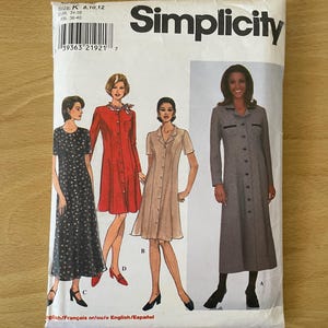 Puede incluir: Un paquete de patrones de costura Simplicity con ilustraciones de cuatro diseños de vestidos diferentes. El paquete es blanco con el nombre de la marca en letras negras grandes. La talla es K 8, 10, 12. El paquete también incluye texto en francés e inglés.