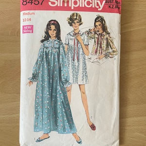 May include: Simplicity sewing pattern number 8457 for a nightgown. The pattern is for sizes 12-14 and features three models wearing different styles of nightgowns. The nightgowns are all floral patterned and have long sleeves. The pattern is labeled "New Sizing" and "Medium".