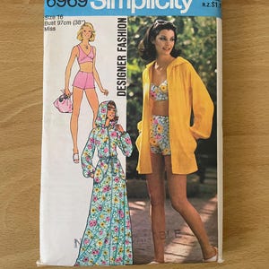 Könnte beinhalten: Vintage Simplicity Designer Fashion Schnittmuster, Größe 16, mit Illustrationen von Bademode und einem Kapuzenmantel. Das Muster enthält ein Brustmaß von 97 cm. Das Cover hat ein blaues und gelbes Farbschema.