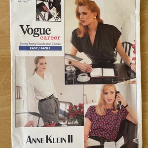 Puede incluir: Patrón de costura Vogue Career número 2069 de Anne Klein II. El patrón incluye instrucciones para tres blusas diferentes: una blusa negra con cuello en V, una blusa blanca con cuello y una blusa rosa con cuello redondo y estampado floral. El patrón está clasificado como fácil de coser.