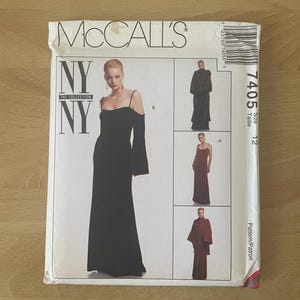 Puede incluir: Un sobre de patrón de costura McCall's con una mujer en un vestido de noche negro con mangas descubiertas. El sobre incluye el texto "NY NY THE COLLECTION" y el número de patrón 7405.