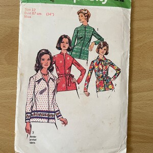 Puede incluir: Patrón de costura Simplicity número 6466 para una blusa de mujer. El patrón incluye tres estilos diferentes: una blusa de rayas verdes, una blusa floral roja y una blusa blanca con lunares rojos y un borde azul y blanco. El patrón es para la talla 12, busto 87 cm (34 pulgadas).