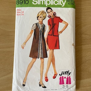 Op de afbeelding: Simplicity naaipatroon nummer 8910 voor een jurk. Het patroon is voor een meisje, maat 12, borstomvang 86 cm. Het patroon bevat twee jurkstijlen, een met een geruite rok en een bruin vest, en de andere met een effen rode rok. Het patroon is gemarkeerd met "Jiffy" en zegt "gemakkelijk te knippen - gemakkelijk te naaien".