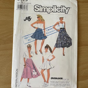 Puede incluir: Patrón de costura Simplicity 8629, con ilustraciones de faldas y tops. El patrón incluye el texto "Jiffy" y "Overlock/Serger". La talla es N (10+12+14). El patrón es para faldas y tops.