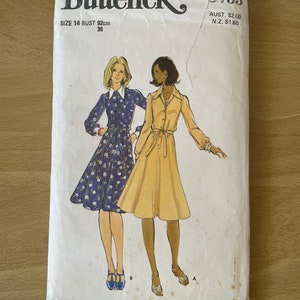 Könnte beinhalten: Vintage-Schnittmuster für ein Kleid, Butterick Muster Nummer 5733, Größe 14, Brustumfang 92 cm (36 Zoll). Das Muster zeigt zwei Frauen, die Kleider tragen, eines mit Blumenmuster und das andere in einer unifarben.