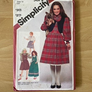 May include: Simplicity sewing pattern number 5672 for a girl's dress with a plaid skirt and a vest. The pattern includes instructions on how to work with plaids.