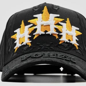 May include: Black baseball cap with embroidered yellow star and white "H" logo. The cap features the word "FOREVER" on the brim. A stylish accessory for sports fans.