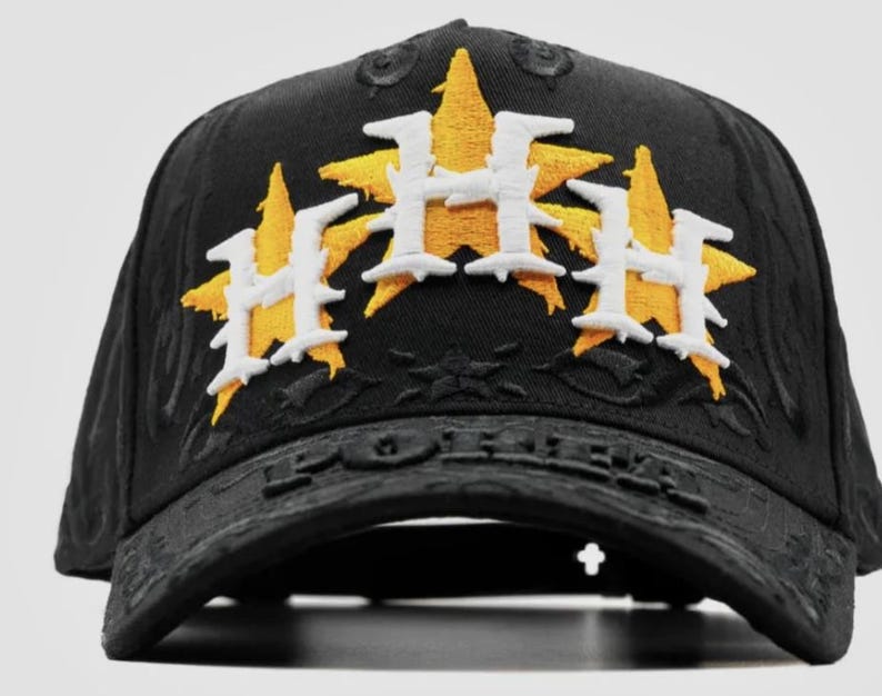 May include: Black baseball cap with embroidered yellow star and white "H" logo. The cap features the word "FOREVER" on the brim. A stylish accessory for sports fans.