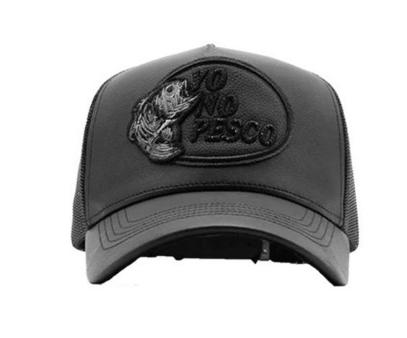 May include: Black baseball cap with a curved peak and mesh back. The cap features a leather patch with a fish graphic and the text "YO NO PESCO" in raised lettering. The cap is a dark grey colour.
