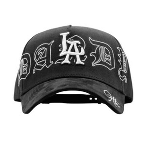 May include: Black baseball cap featuring the white embroidered text "LA Dad" in a gothic font. The cap has a curved peak and a textured finish.