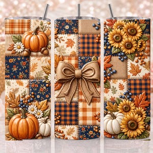May include: A cylindrical tumbler featuring a patchwork design of autumn-themed patterns including orange pumpkins, yellow sunflowers, blue berries, plaid squares, and fall leaves. A large tan bow is centered on the design, and a metal straw is inserted.