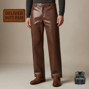 May include: Brown trousers featuring a textured crocodile skin pattern, a button closure, and belt loops. The trousers are paired with brown leather shoes. A rectangular badge in the upper left corner reads DELIVER DUTY PAID, and a small icon in the lower right corner displays a waistcoat with the text crocskins.