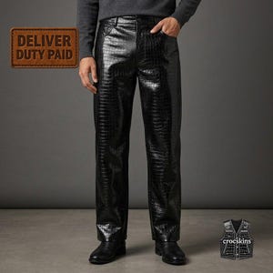 May include: Black trousers featuring a glossy, embossed crocodile skin texture. The pants have a straight-leg cut, a standard waistband with belt loops, and a classic five-pocket design. The fabric has a reflective finish and a dark, uniform color.