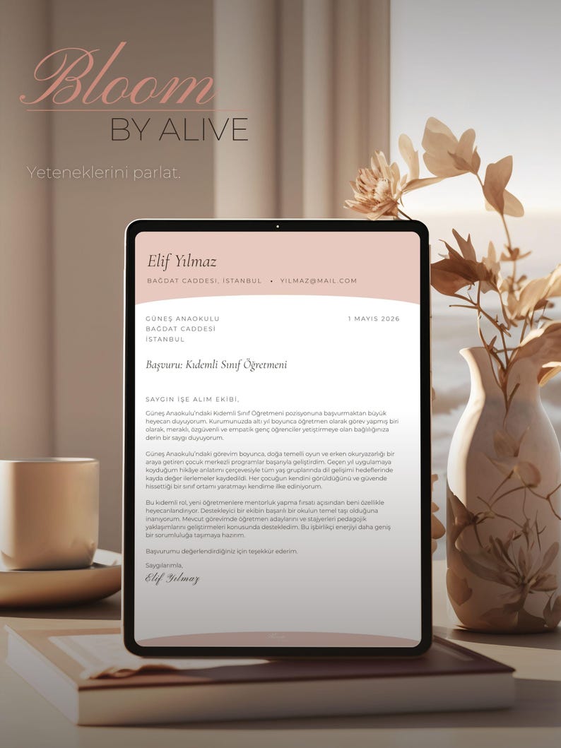 K&ouml;nnte beinhalten: Ein digitales Tablet zeigt einen Lebenslauf mit dem Namen "Elif Yilmaz" und dem Text "Bloom by Alive". Das Tablet steht auf einer Holzoberfl&auml;che neben einem Buch, einer Tasse und einer Vase mit getrockneten Blumen.