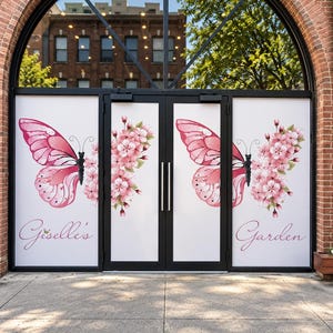 May include: A set of double glass doors featuring a large pink butterfly graphic on each side, with one wing composed of pink cherry blossoms. The text 'Giselle's' is printed on the left panel and 'Garden' is printed on the right panel in script.