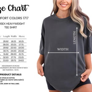 May include: A size chart for a Comfort Colors 1717 unisex heavyweight tee shirt. The chart shows measurements in inches for sizes S through 4XL, including length, width, and sleeve dimensions. The shirt is dark gray and has a relaxed fit.