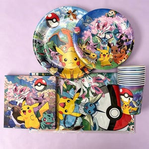 May include: A set of party supplies featuring Pokemon characters including Pikachu, Eevee, and various evolutions. The collection includes two round paper plates, a stack of paper cups with blue stripes, and square napkins, all decorated with colorful graphics.