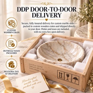 May include: A round marble sink with beige and brown veining, nestled inside a light-colored wooden shipping crate with white foam padding. The crate features text reading Natural Stone Timeless Beauty Worldwide and includes shipping icons.