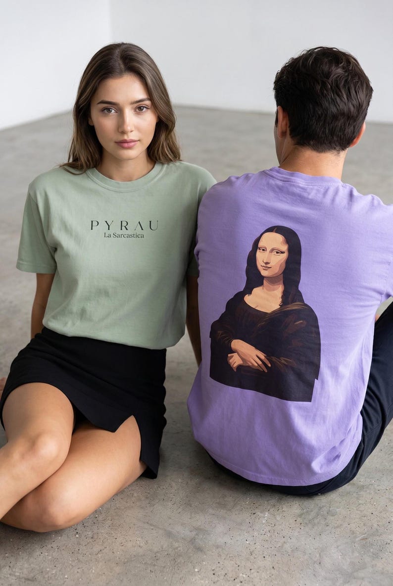 A woman in a light green t-shirt with "PYRAU La Sarcastica" printed on the front sits next to a man in a purple t-shirt with a Mona Lisa graphic on the back.