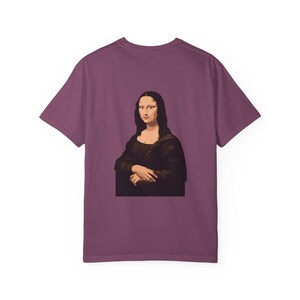 The back of a dark red t-shirt shows a graphic of the Mona Lisa portrait.