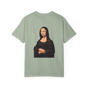 The back of a light green t-shirt shows a graphic of the Mona Lisa portrait.