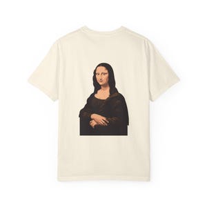 The back of a cream-colored t-shirt features a graphic of the Mona Lisa portrait.